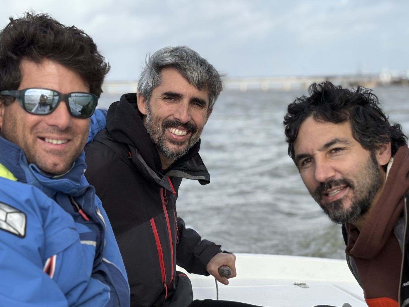 Three participants in the cockpit of a sailing dinghy