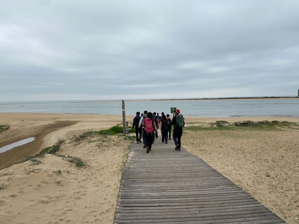 A group walking the boardwalk out towards the sand spit